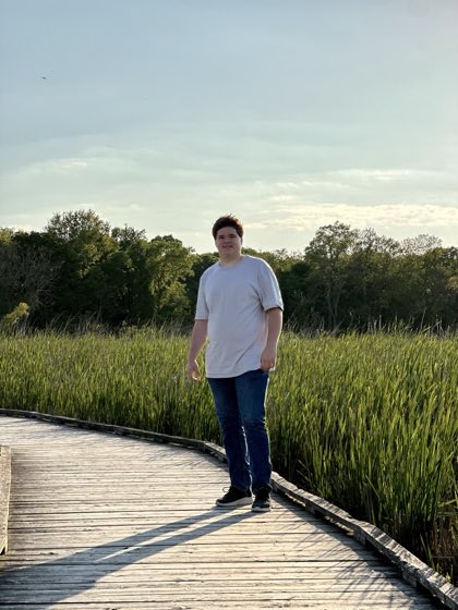 Kaleb Kornelsen on a boardwalk through tall grass